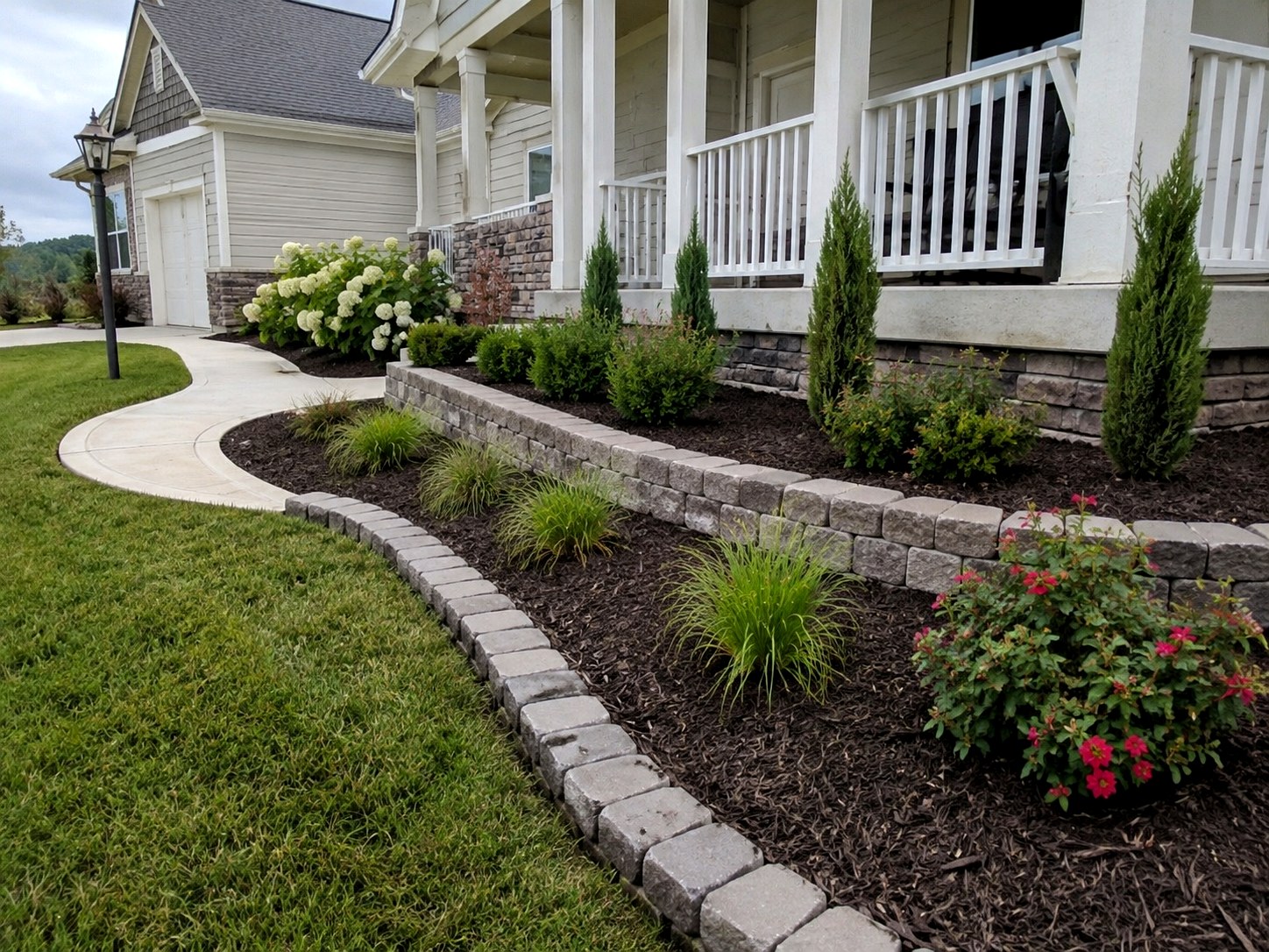 Finished front yard landscaping with block edging, mulch beds, and planting design